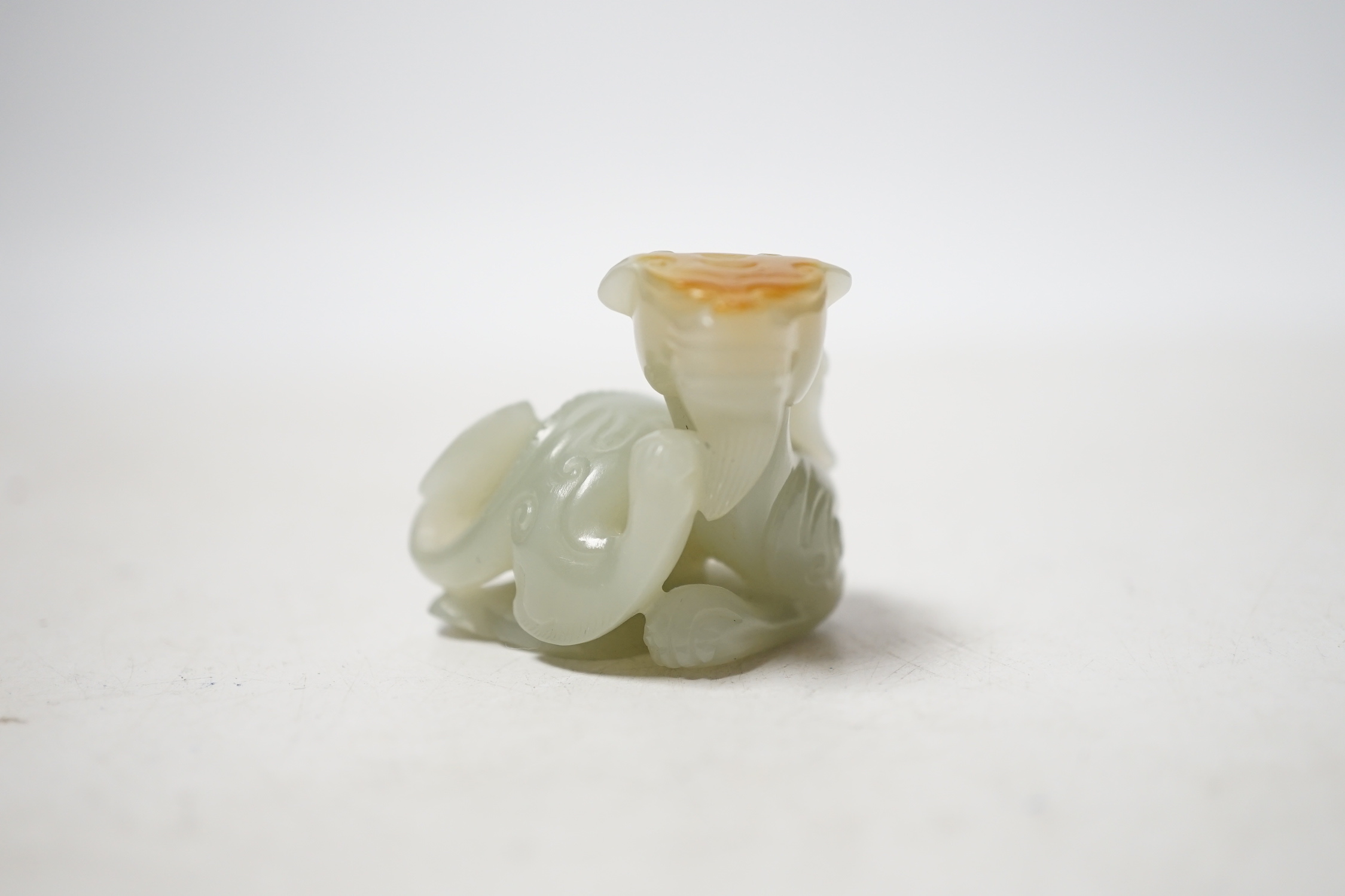 A Chinese pale celadon and russet skin jade figure of a dragon, 4cm high